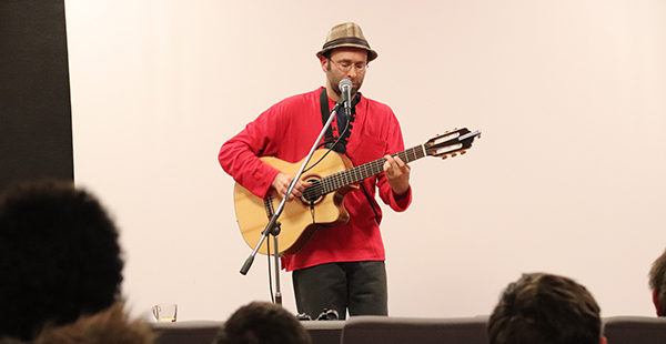 Photo représentant l'artiste Cyrarno du Patelin jouant de la musique devant un publique.