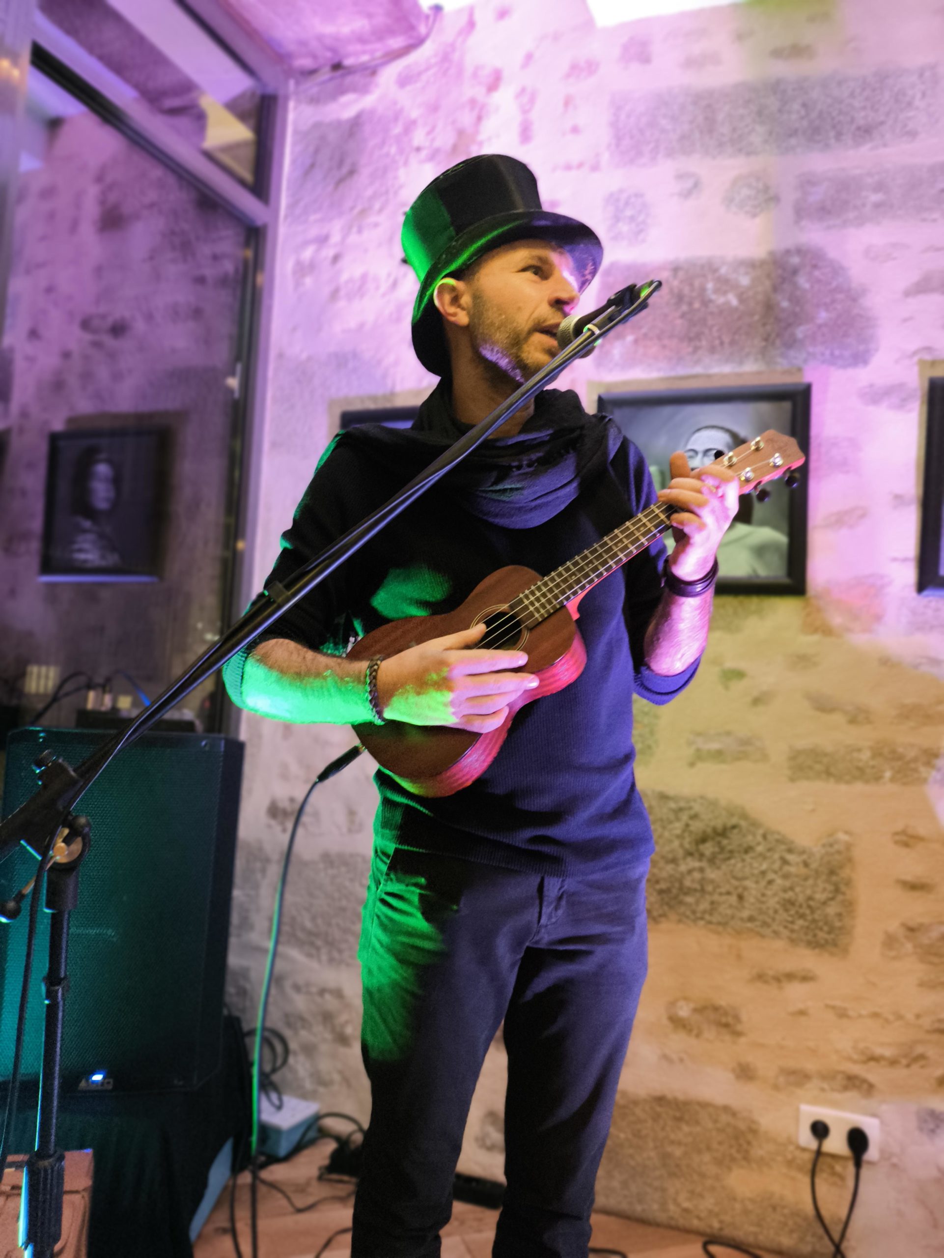 Astian Bes qui chante dans un micro avec un Ukulélé dans la main.