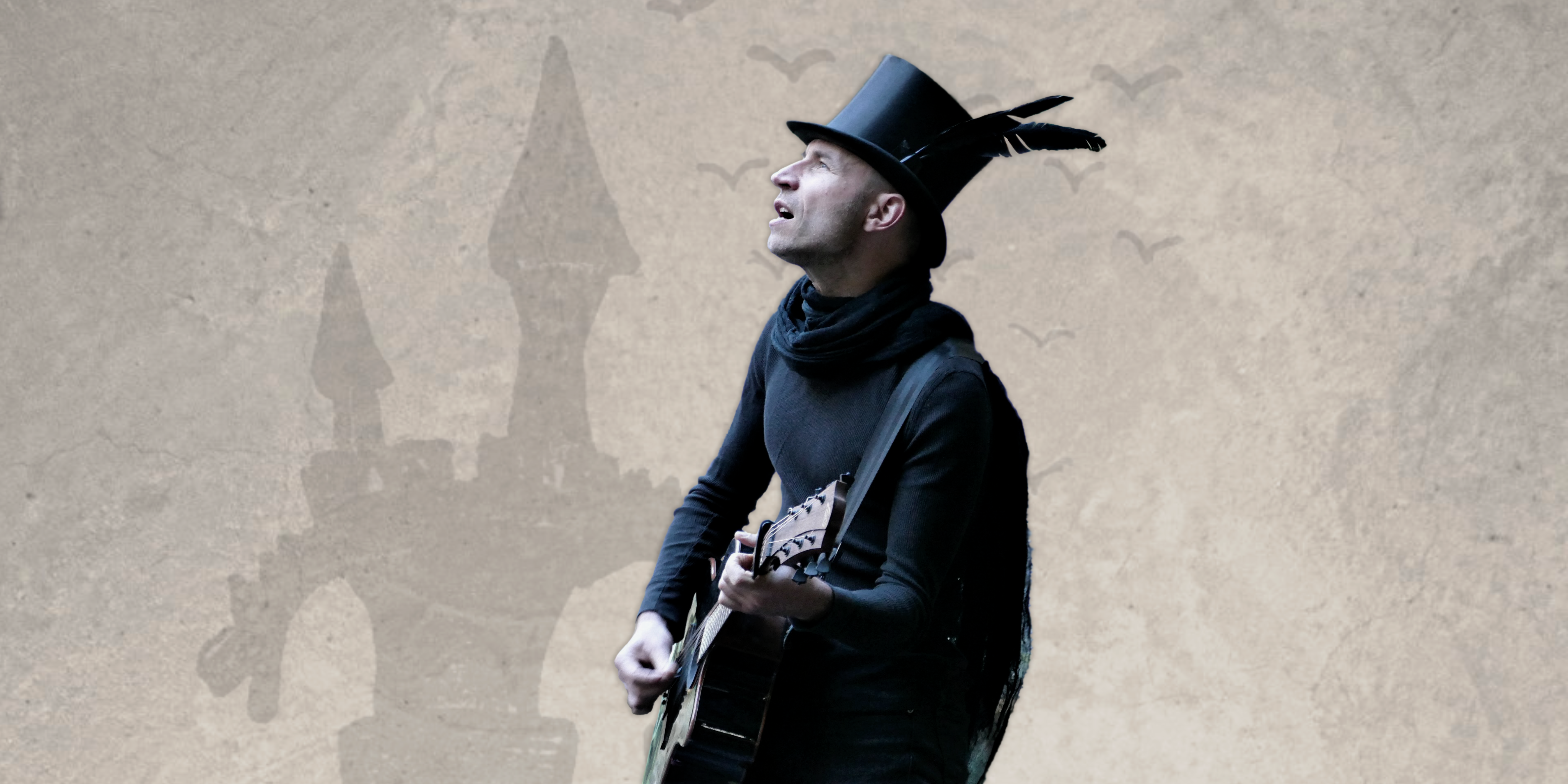Astian Bes est de profil, chante avec une guitare à la main.